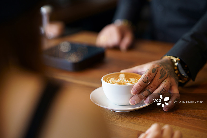 咖啡师为顾客端上一杯拿铁咖啡图片素材
