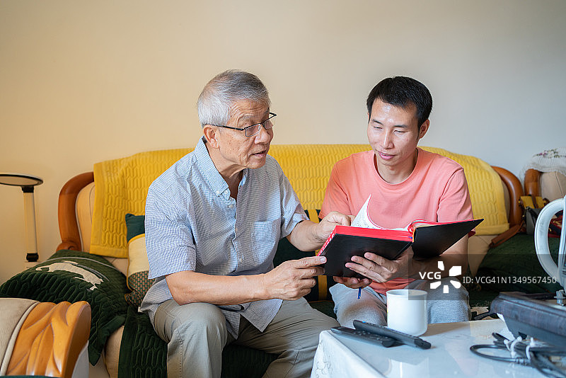 老人的父亲和儿子正在客厅喝茶聊天图片素材