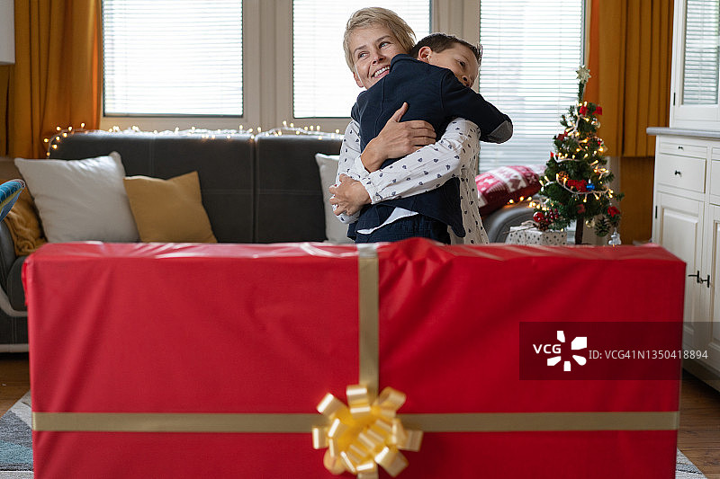 圣诞节期间，母亲抱着她惊讶的儿子图片素材