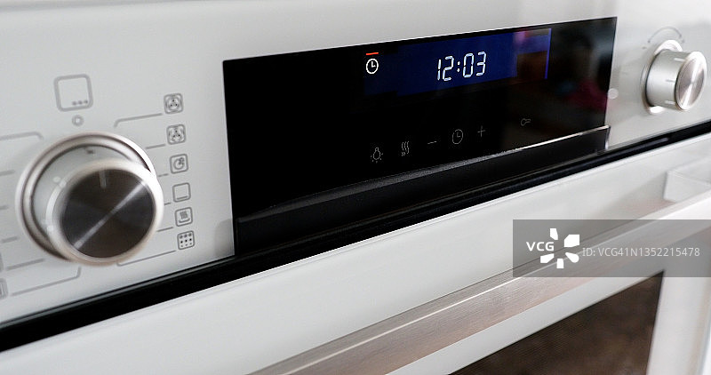 按钮和控制面板的现代烤箱与时钟定时器闪烁。图片素材