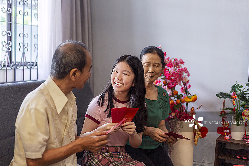 十几岁的孙女在春节期间收到祖父母的红包图片素材