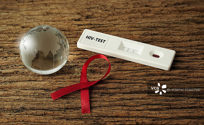 地板上的红丝带水晶球HIV快速检测试剂盒。图片素材