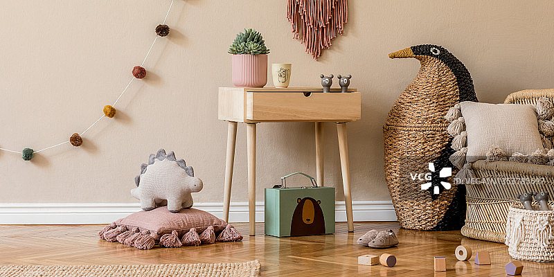 时尚的斯堪的纳维亚儿童房间的玩具，泰迪熊，毛绒动物，自然pouf和儿童配件。现代室内与米色背景墙。模板。设计家里举办。图片素材