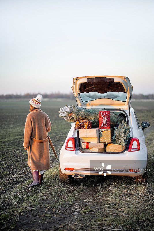 女人和一辆装满新年礼品盒的车图片素材