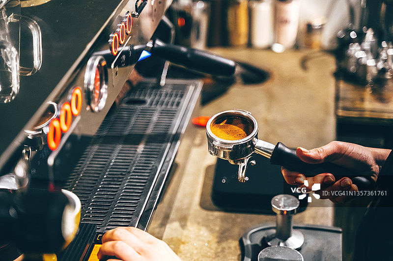 咖啡机意式浓缩咖啡的制作，将磨碎的咖啡剂量捣固在滤嘴中的过程图片素材
