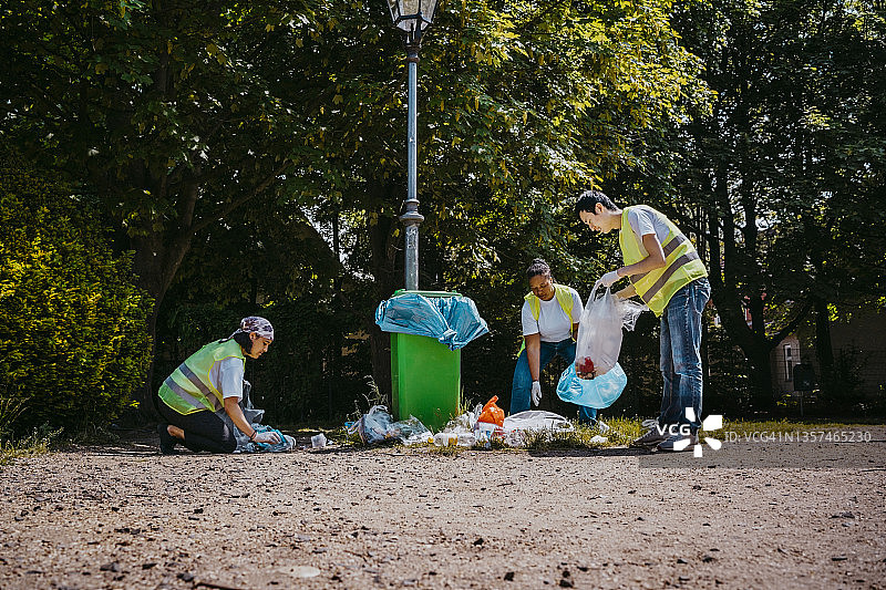 男性和女性活动人士在公园捡拾塑料垃圾图片素材
