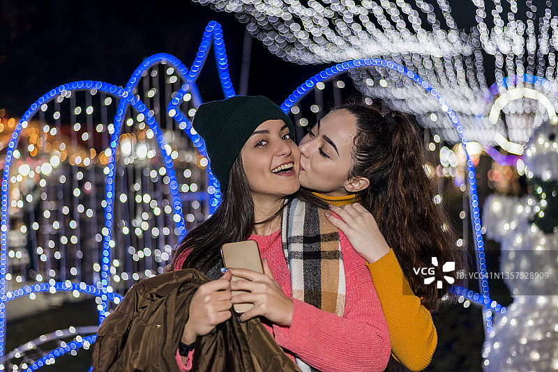 两个女性朋友走在露天的圣诞集市上图片素材
