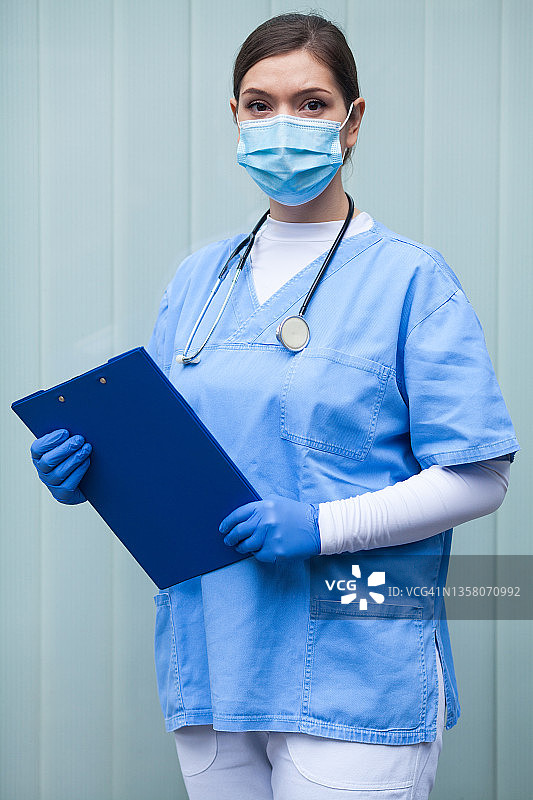 英国急救护理人员，身穿个人防护装备，手拿剪贴板图片素材