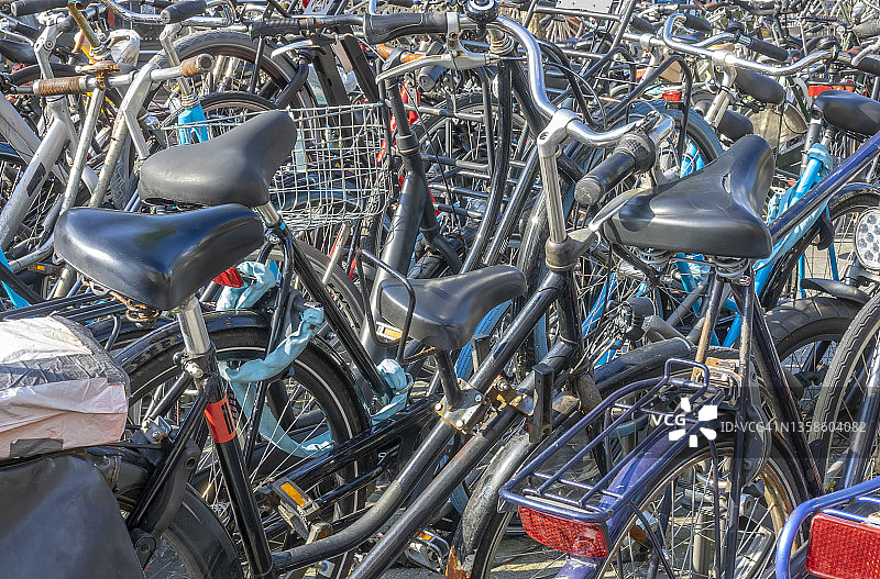 阳光明媚的日子，许多自行车停放在自行车停放处图片素材
