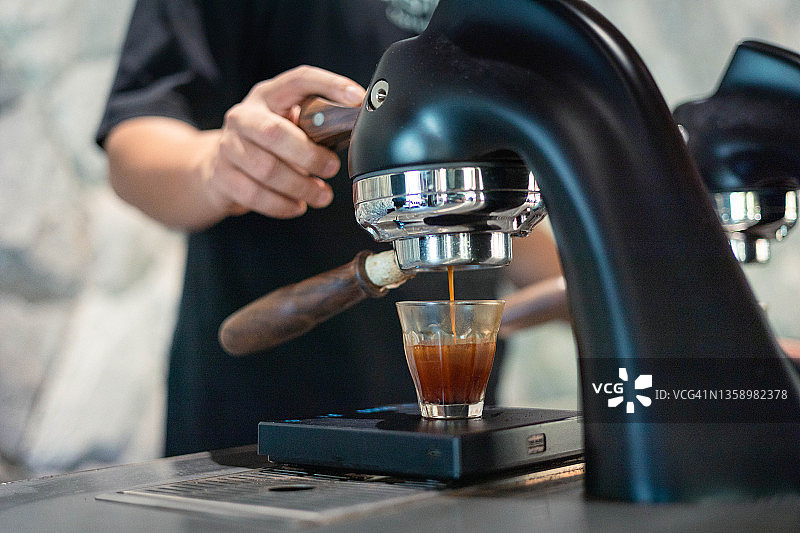 浓缩咖啡从不锈钢滤嘴滴入咖啡杯图片素材