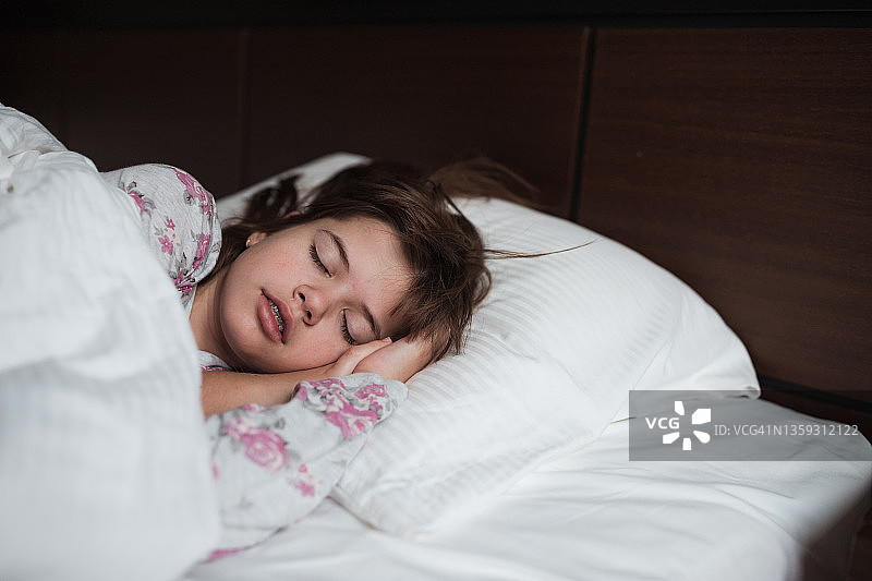 一个女孩睡在旅馆的床上图片素材