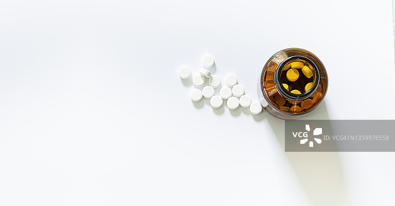 药丸和药瓶在白色背景，白色药丸在白色背景图片素材