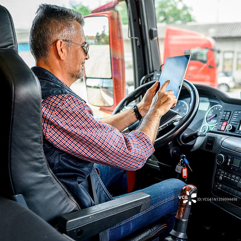 成熟的卡车司机使用手机应用程序图片素材