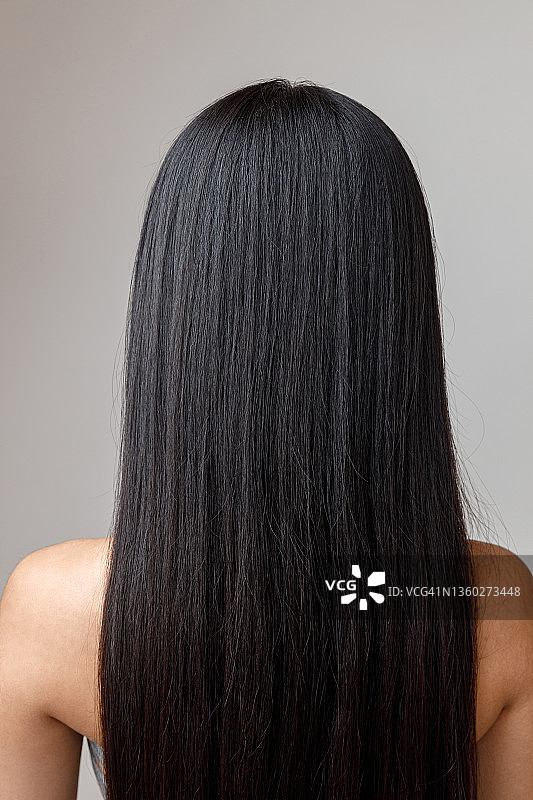 黑发的年轻女人长头发站在工作室图片素材
