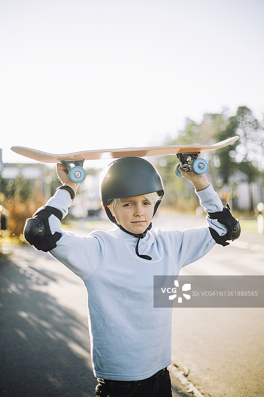 头顶滑板的男孩的肖像图片素材