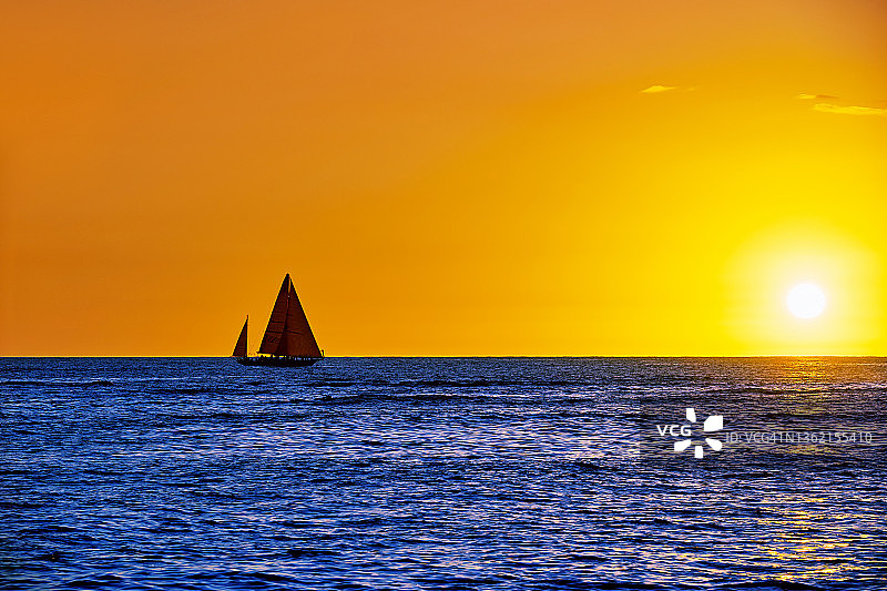 在海上日落地平线上航行的帆船，夏威夷，美国图片素材