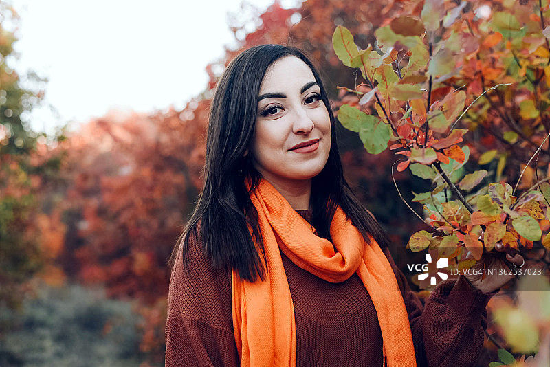 一个美丽的女孩的肖像在秋天的自然背景。秋天的气氛。休闲风格。图片素材