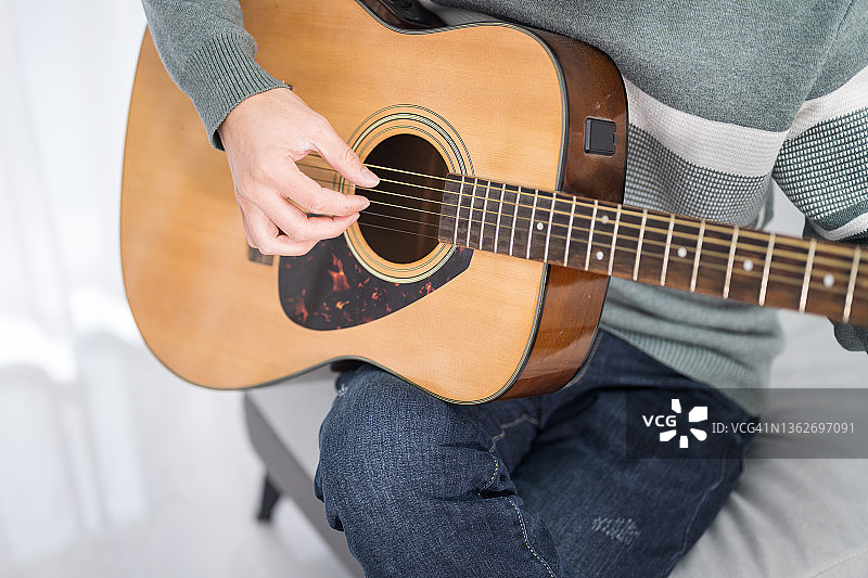 一个年轻人弹吉他的手的特写图片素材