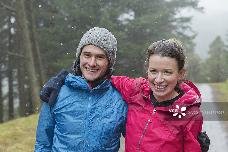 肖像幸福的夫妇徒步在雨天的树林图片素材