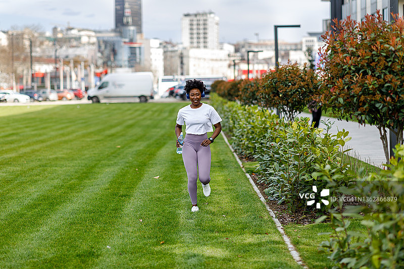 年轻的非洲女运动员在城市中奔跑。图片素材