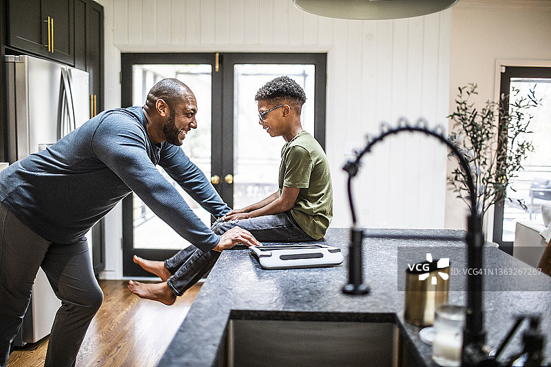 父亲和儿子在住宅厨房谈话图片素材