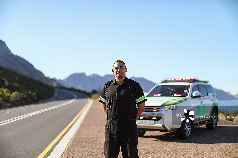 一名男性护理人员站在他的应急车辆前。图片素材