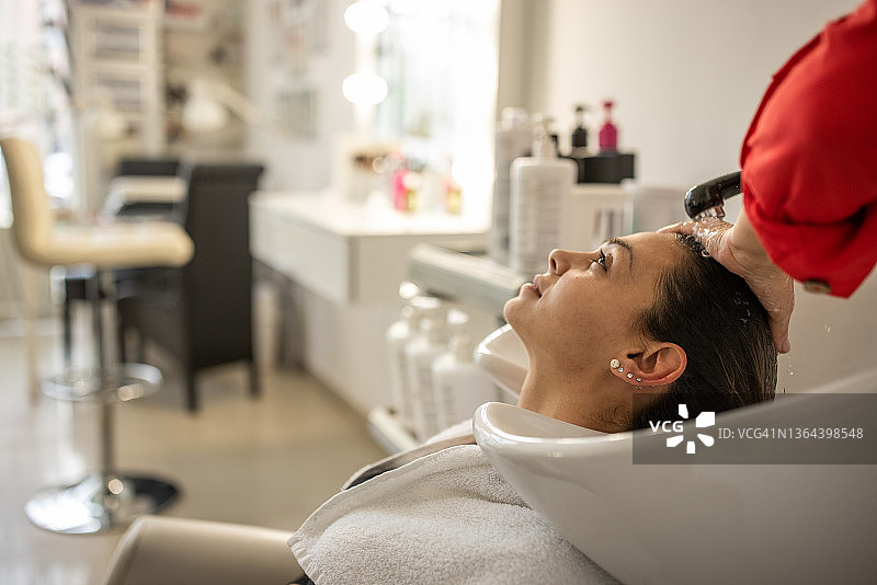 近景理发师洗客户的头发，在现代发廊图片素材