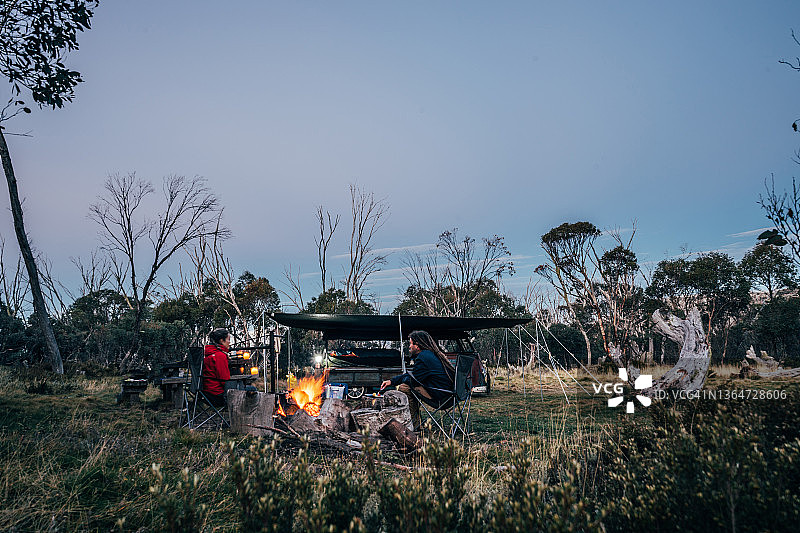 澳大利亚阿尔卑斯山国家公园，一对情侣在篝火旁放松图片素材