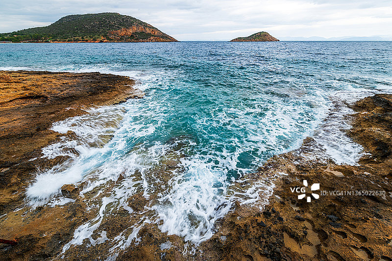 阴天，海浪拍打着岩石海岸图片素材