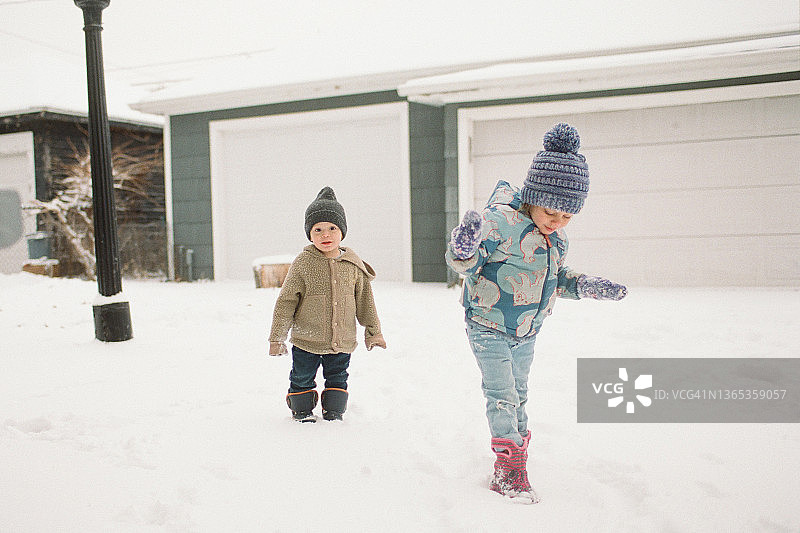 在一个大雪天和学校停课后，两个兄弟姐妹在纽约布法罗享受他们的后院。图片素材