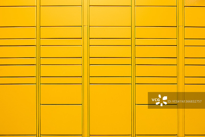 黄色金属储物柜，所有储物柜关闭。储物柜、更衣室、大学、学院、包裹、运输和储存的概念。图片素材