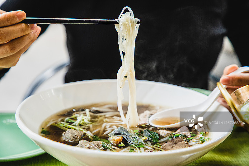 享受东南亚美食——越南河粉、绿咖喱牛肉和炒菠菜图片素材