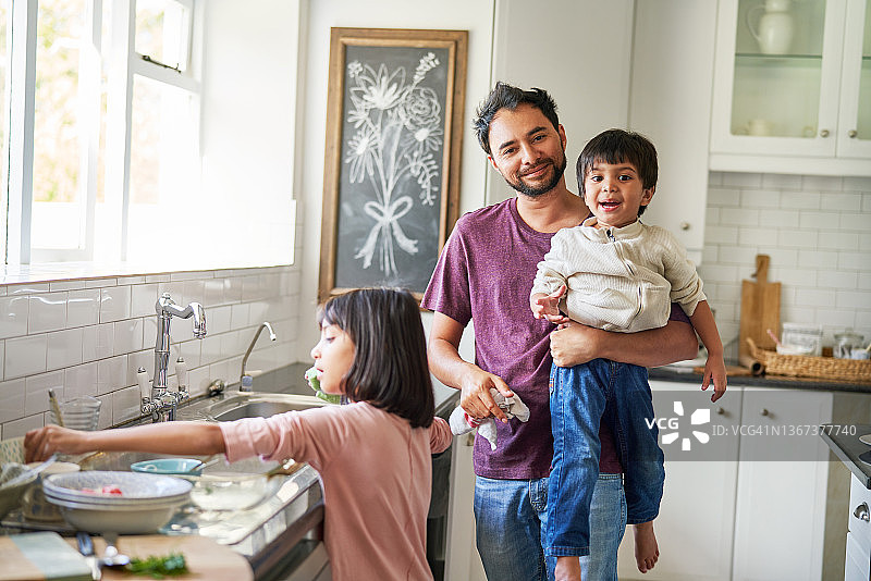 快乐的父亲和孩子们在厨房里洗碗图片素材