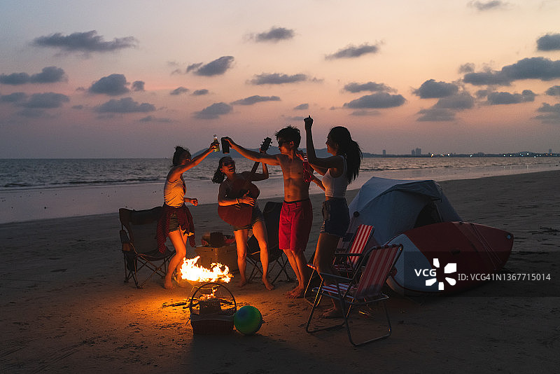一群亚洲朋友在夏天的海滩露营图片素材