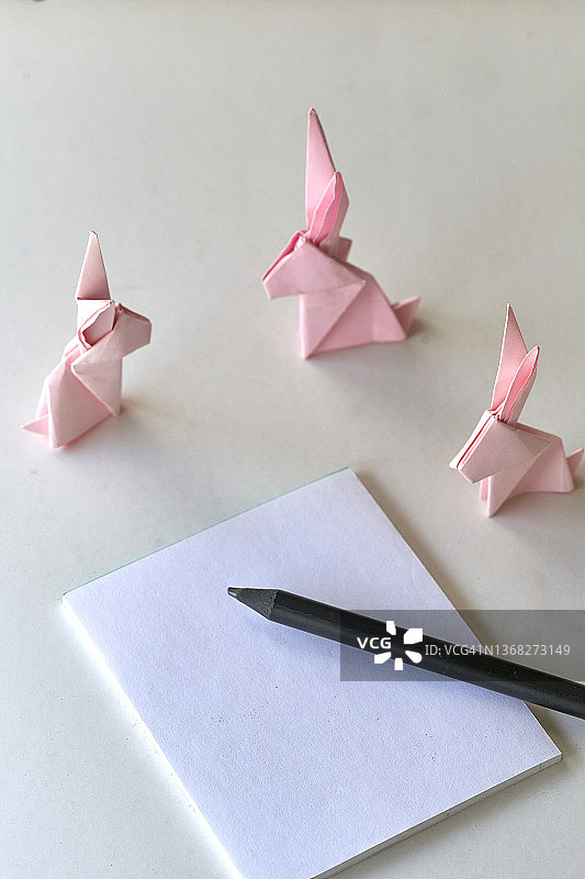 粉红色折纸兔子在白色背景与复制空间图片素材