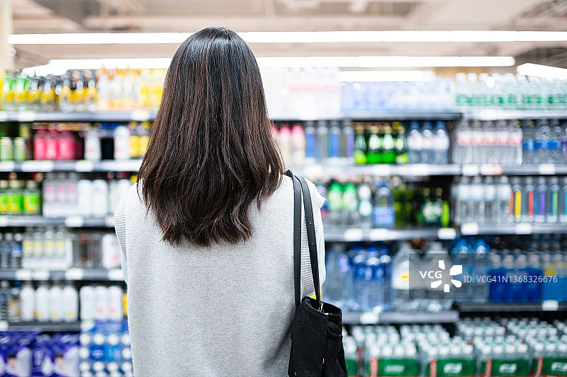 年轻的中国女性在现代超市购物图片素材