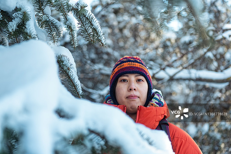 女性背包客在冬天的森林里的肖像图片素材