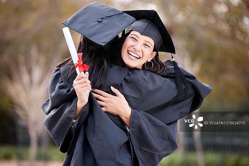 一名年轻女子在毕业典礼上拥抱她的朋友图片素材