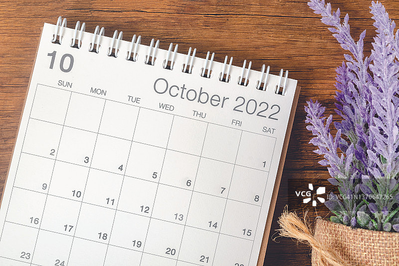 俯视图挂历台2022年10月是组织者在木桌背景上规划和提醒的月份。商业计划预约会议概念图片素材