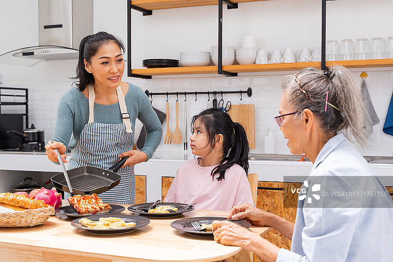 亚洲家庭在周末一起在家做饭和吃午饭图片素材