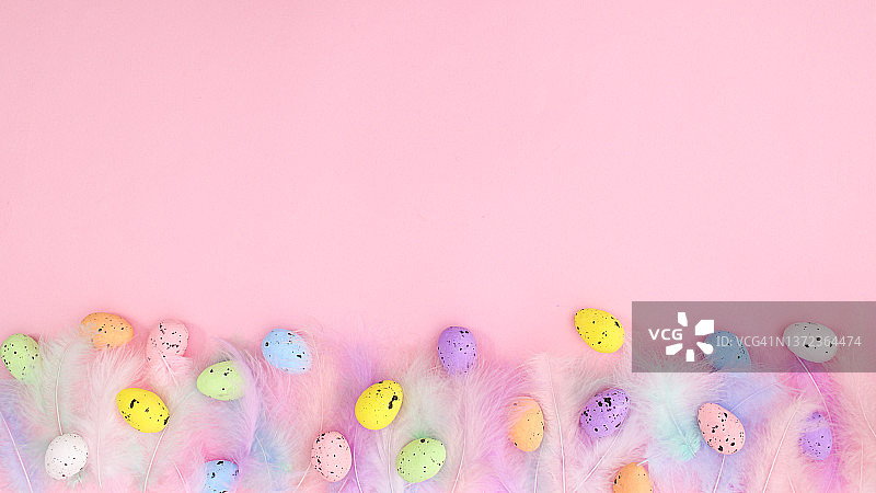 粉彩时尚的羽毛在明亮的粉红色背景与彩色鸡蛋。春天的概念。创意复制空间复活节平坦的奠定组成“n图片素材