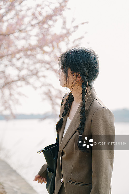 美丽的亚洲女孩在樱桃树下图片素材