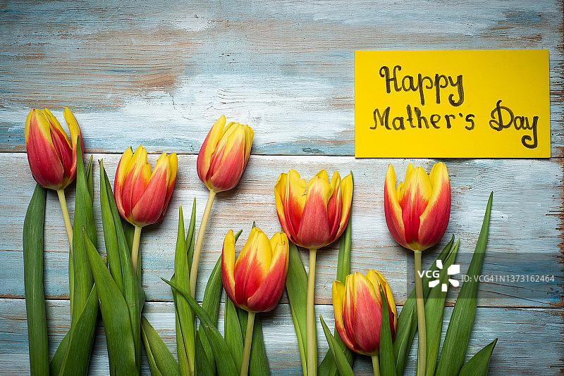 木桌上放着一张印有各色郁金香的母亲节贺卡图片素材