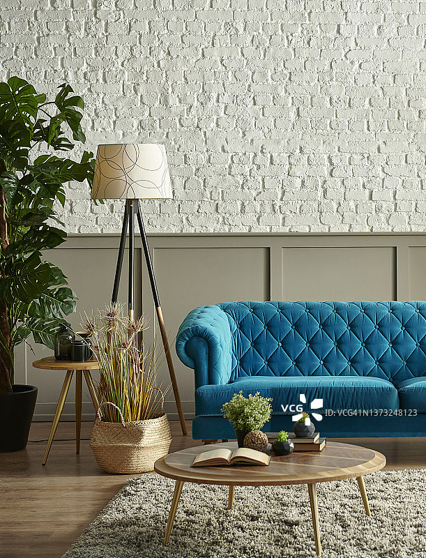 棕色经典格子和白色砖墙前的蓝色绗缝沙发，绿色植物灯设计的毯子花瓶，时钟设计。图片素材