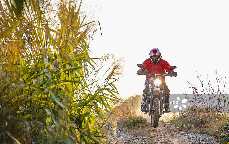在泰国崎岖的地形上，一名男子骑着他的扰频器式摩托车图片素材