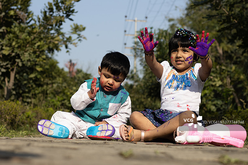 快乐的亚洲印度孩子男孩和女孩享受节日的颜色与胡里彩粉称为Gulal或Rang图片素材