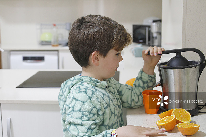 小男孩在做橙汁图片素材