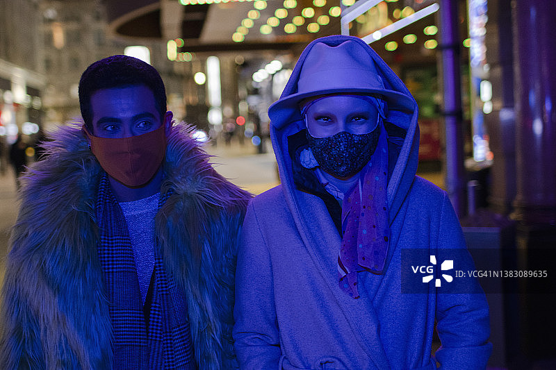 肖像时尚夫妇戴着口罩在城市人行道晚上图片素材