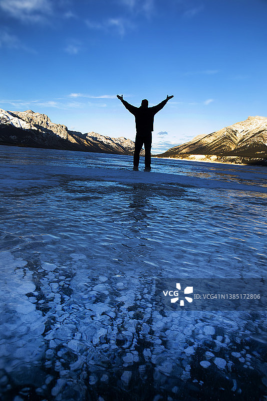 男子站在结冰的湖面上。图片素材