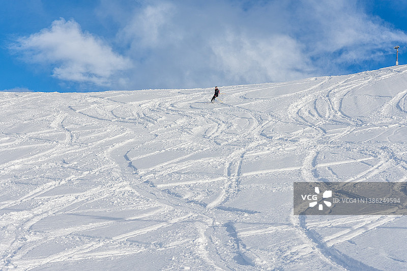 挪威，一名女子从雪山上滑雪而下图片素材